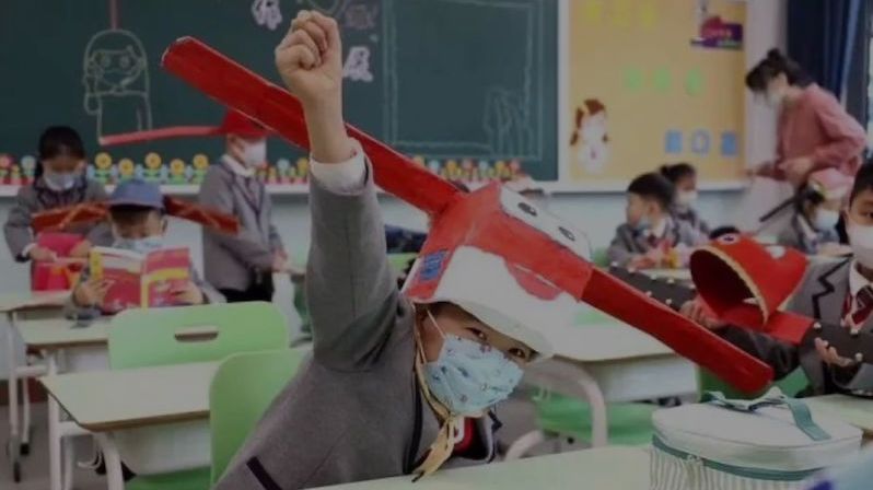 Čínské děti si vyrobily metrové klobouky. Mají jim pomoct s odstupem